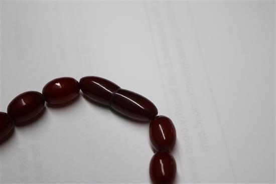 A single strand graduated simulated cherry amber oval bead necklace, gross weight 68 grams, 70cm.